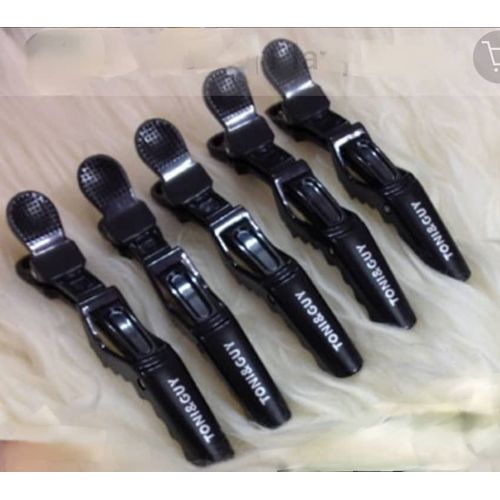 “Toni & Guy black crocodile hair clips set on white background.”