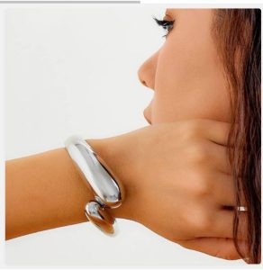 Model wearing minimalist cuff bracelet on wrist.